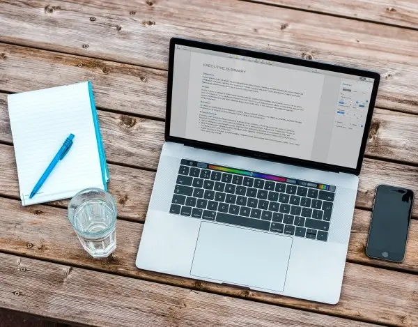 Laptop, pen and paper that can be used for CV writing service